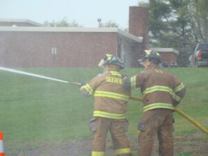 2 firefighters spraying a hose
